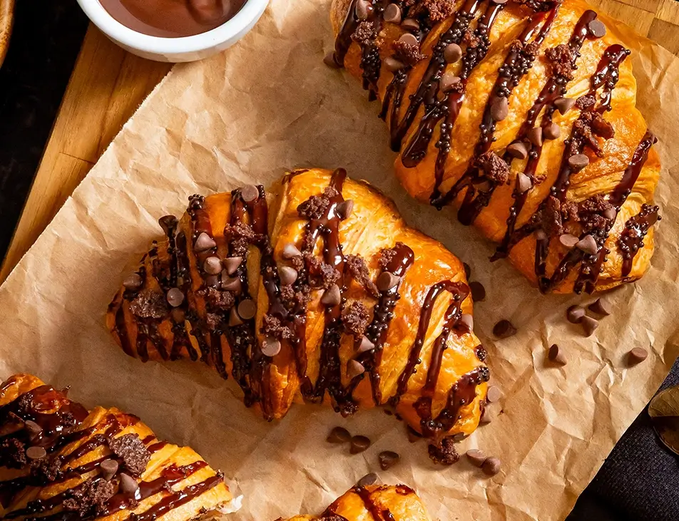 Croissant recheado com pedaços de brownie e coberto com chocolate