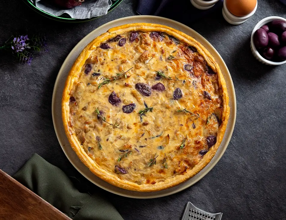 Quiche de bacalhau assada em massa crocante com recheio de bacalhau, queijo e azeitonas